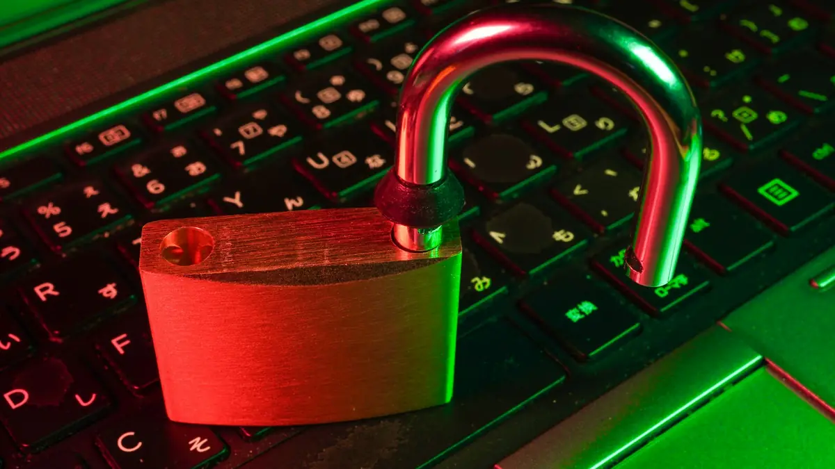 Open red padlock on a laptop keyboard lit red and green